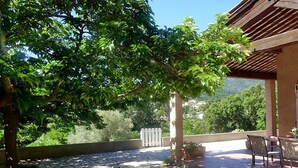 Um pátio com piso de pedra, pérgola e mobiliário externo.