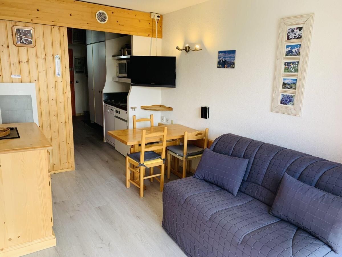 A compact living space with a kitchenette, a dining area, and a sofa.