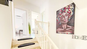 A staircase with white railings and black steps leading to a room. - Tina & Tino by Interhome (Zadar)