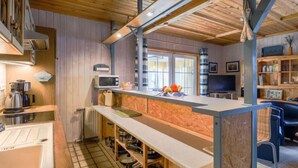 Une cuisine avec des poutres en bois, un four à micro-ondes et un évier.