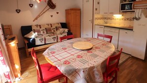 Una cocina acogedora con una mesa de comedor, sillas, un sofá y un armario.