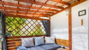 Una habitación acogedora con una cama de madera, una mesita pequeña y vistas a través de una ventana con celosía.