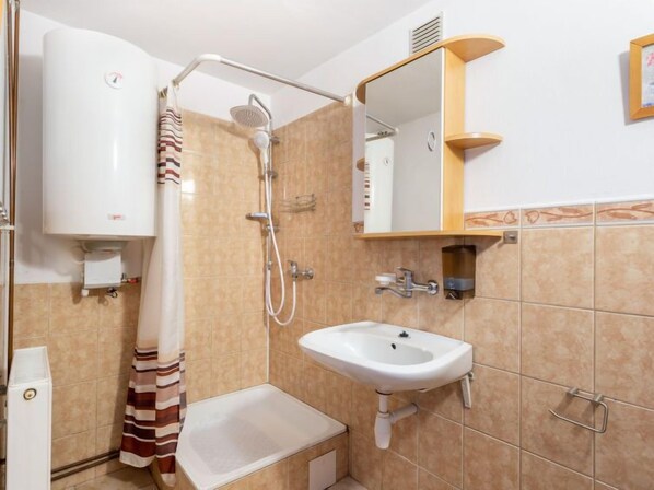 Une salle de bain avec une douche, un lavabo et des toilettes.