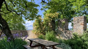 Ein Picknicktisch in einem Garten mit einer Steinmauer und Bäumen.