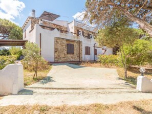 Traditional Mediterranean-style villa with a stone facade, white walls, and a tiled roof.