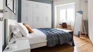 A bedroom with a bed, bedside table, and a large wardrobe. - UPSTREET Charming & Comfy 2BD Apt-Acropolis (Athens)