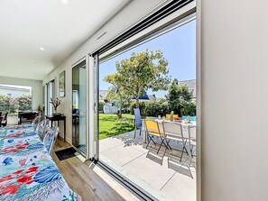 A modern room with a large sliding glass door leading to an outdoor patio area.