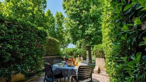 Eine Terrasse mit Essplatz, umgeben von üppiger Vegetation.