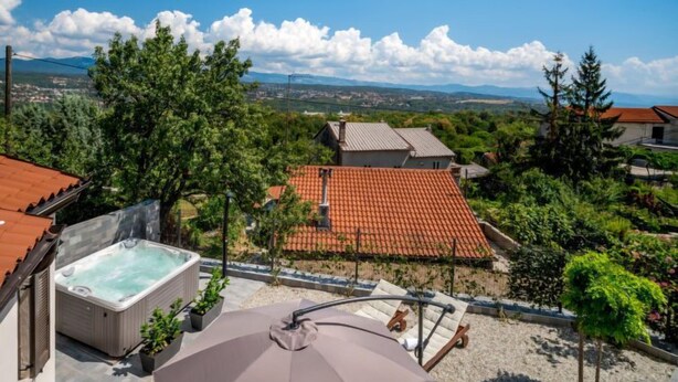 A rooftop terrace with a hot tub, lounge chairs, and a view of a town with red-roofed houses. - Vacation home Amberg by Interhome (Opatija/Kastav)