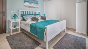 A bedroom with a bed, a nightstand, a lamp, a painting, and an air conditioning unit. - Vacation home Amberg by Interhome (Opatija/Kastav)