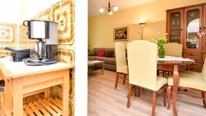 Un comedor con una mesa y sillas de madera, una cafetera y un armario con puertas de cristal.