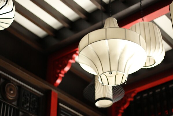 A ceiling with hanging lamps and a red architectural detail.