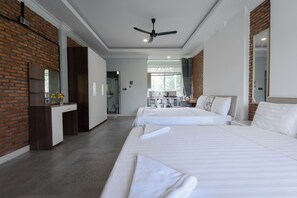 A hotel room with two beds, a desk, a mirror, and a ceiling fan. - Sanssouci Kep (Kep)