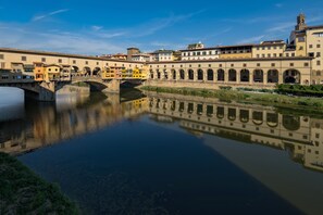 A historic bridge with multiple arches over a calm river, reflecting the surrounding buildings.