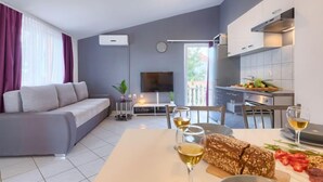 Um apartamento moderno com sala de estar, espaço para refeições e cozinha.
