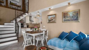 A modern living room with a staircase, a dining area, and two paintings on the wall. - Villa Aurora by Interhome (Pula)