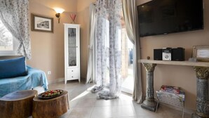 A living room with a sofa, a coffee table, a cabinet, a television, and a statue. - Villa Aurora by Interhome (Pula)