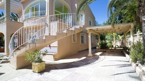 A two-story house with a covered patio, a staircase, and a pool area. - Vacation home Amber by Interhome (Calpe/Calp)