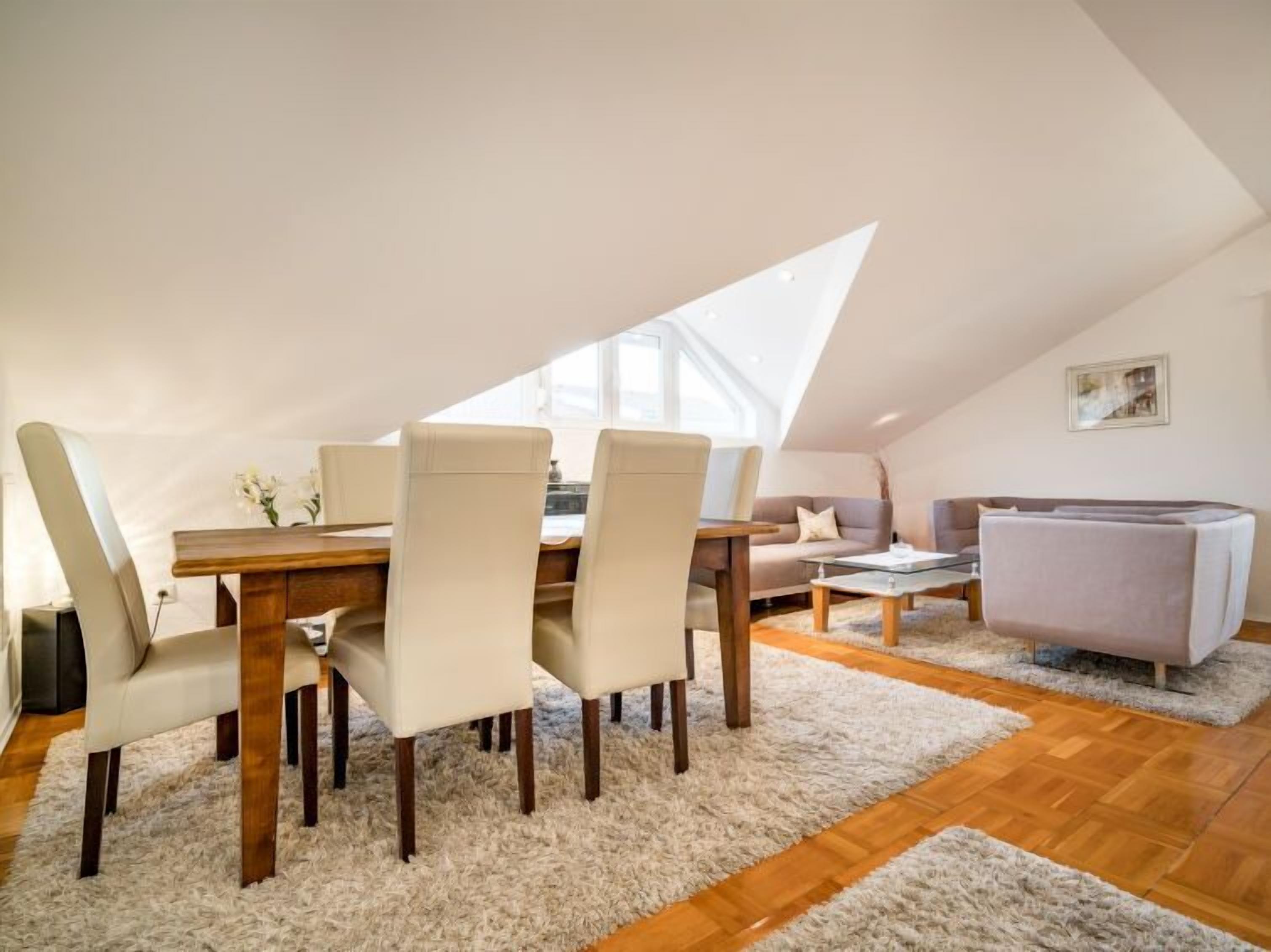 A cozy loft apartment with a dining area, a sofa, and a couch.