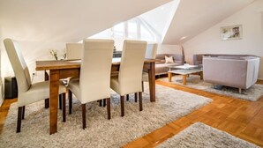 A cozy loft apartment with a dining area, a sofa, and a couch.