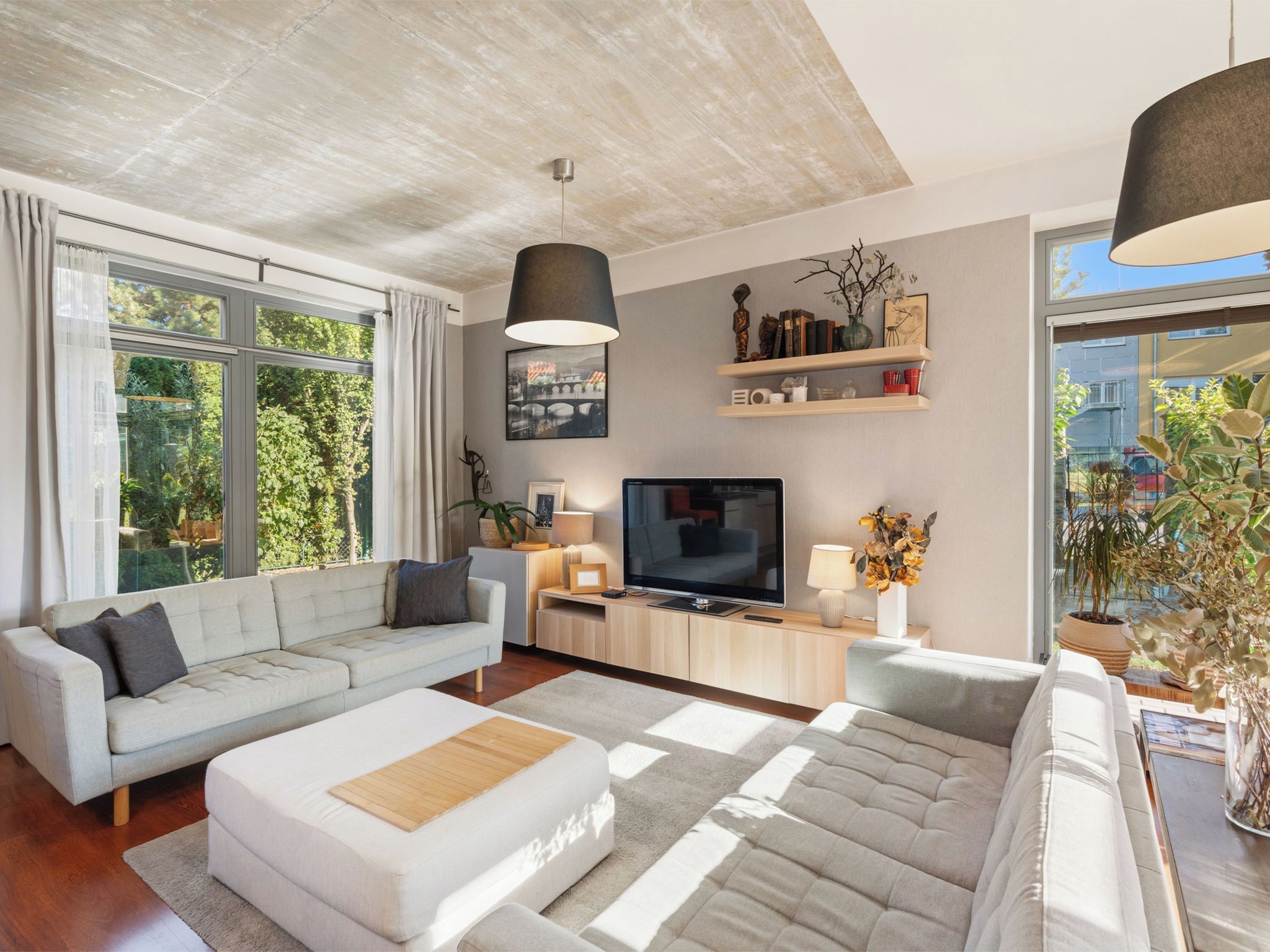 A modern living room with a sofa, TV, and decorative items.
