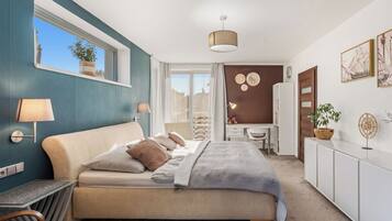A modern bedroom with a bed, bedside lamps, a desk, and a wardrobe.