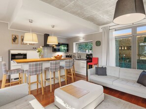 A modern kitchen with bar stools, a dining table, and a large window. - Řeporyje by Interhome (Reporyje)