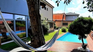 A modern house with a pool, a hammock, and a well-maintained lawn. - Řeporyje by Interhome (Reporyje)
