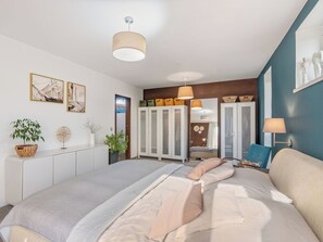 A bedroom with a bed, bedside tables, a wardrobe, and a mirror.