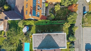 Vista aérea de un edificio con jardín en la azotea, piscina y zona de estacionamiento.