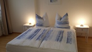 Ein Schlafzimmer mit einem Bett, zwei Nachttischen und einem Schminktisch.