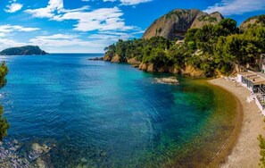 A coastal landscape with clear blue waters, rocky outcrops, and a small building with a white roof near the shore. - Villa Laricio friendliness and serenity in Bonifacio (bonifacio)