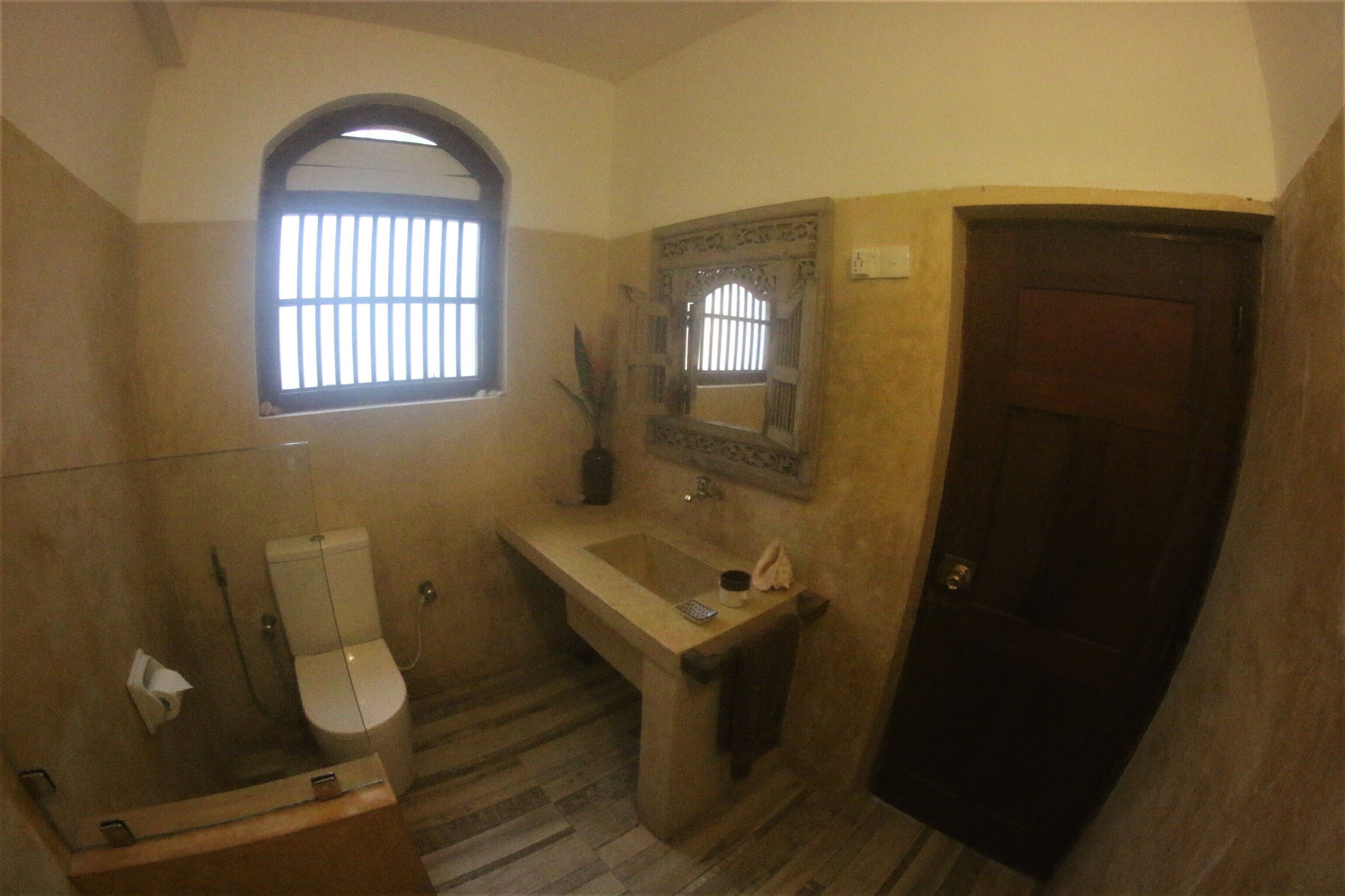 A bathroom with a toilet, sink, and shower area.
