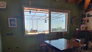 A dining area with a large window, wooden table, and chairs.