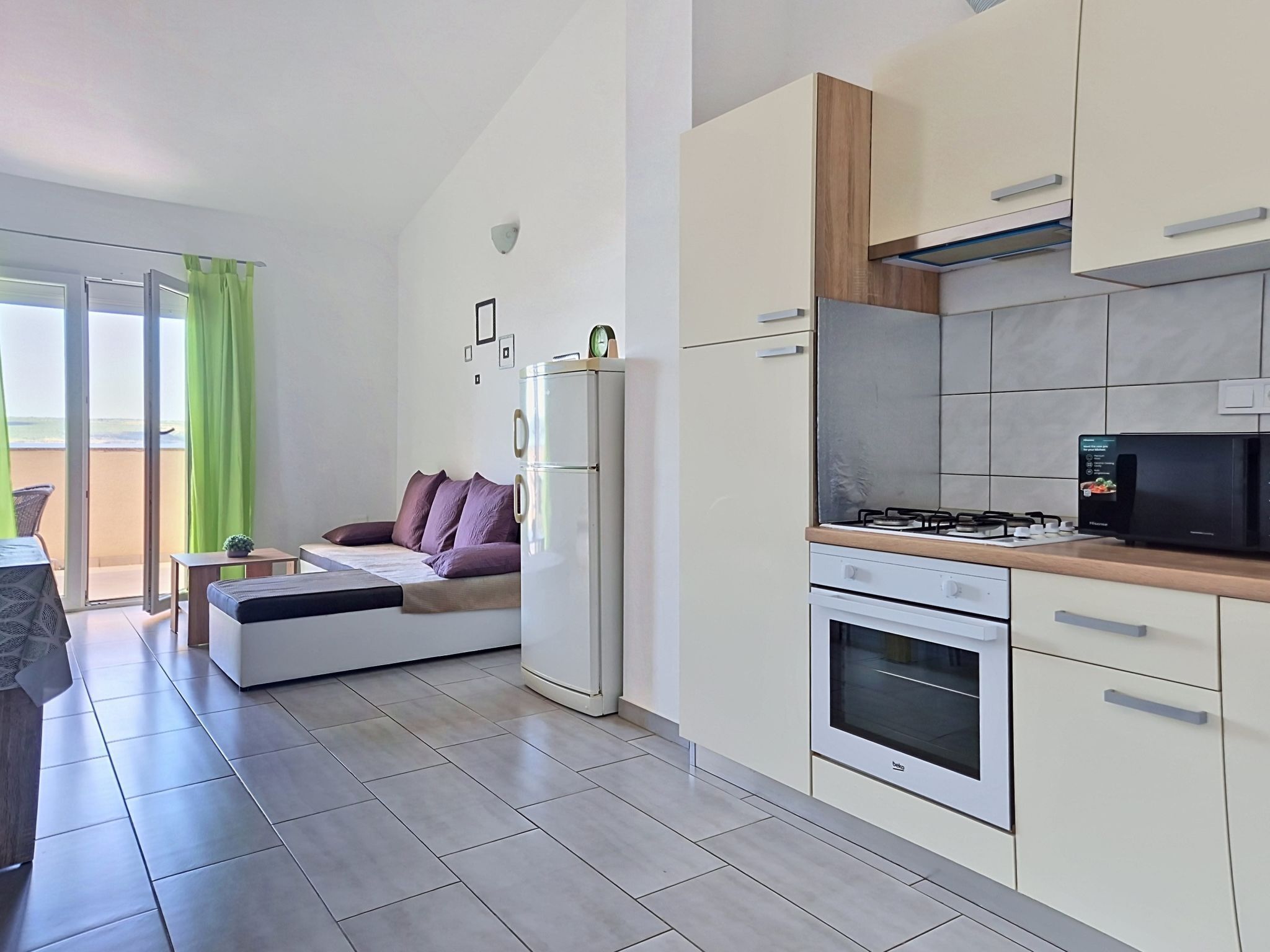 A modern kitchen with a built-in oven, a refrigerator, and a microwave.