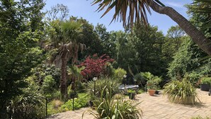 A garden with various potted plants and a small pool area. - Little Treasure in Heart of Old Village Shanklin + Ferry Discount  (Shanklin)