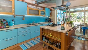 A modern kitchen with blue cabinets, a gas stove, and a coffee machine.