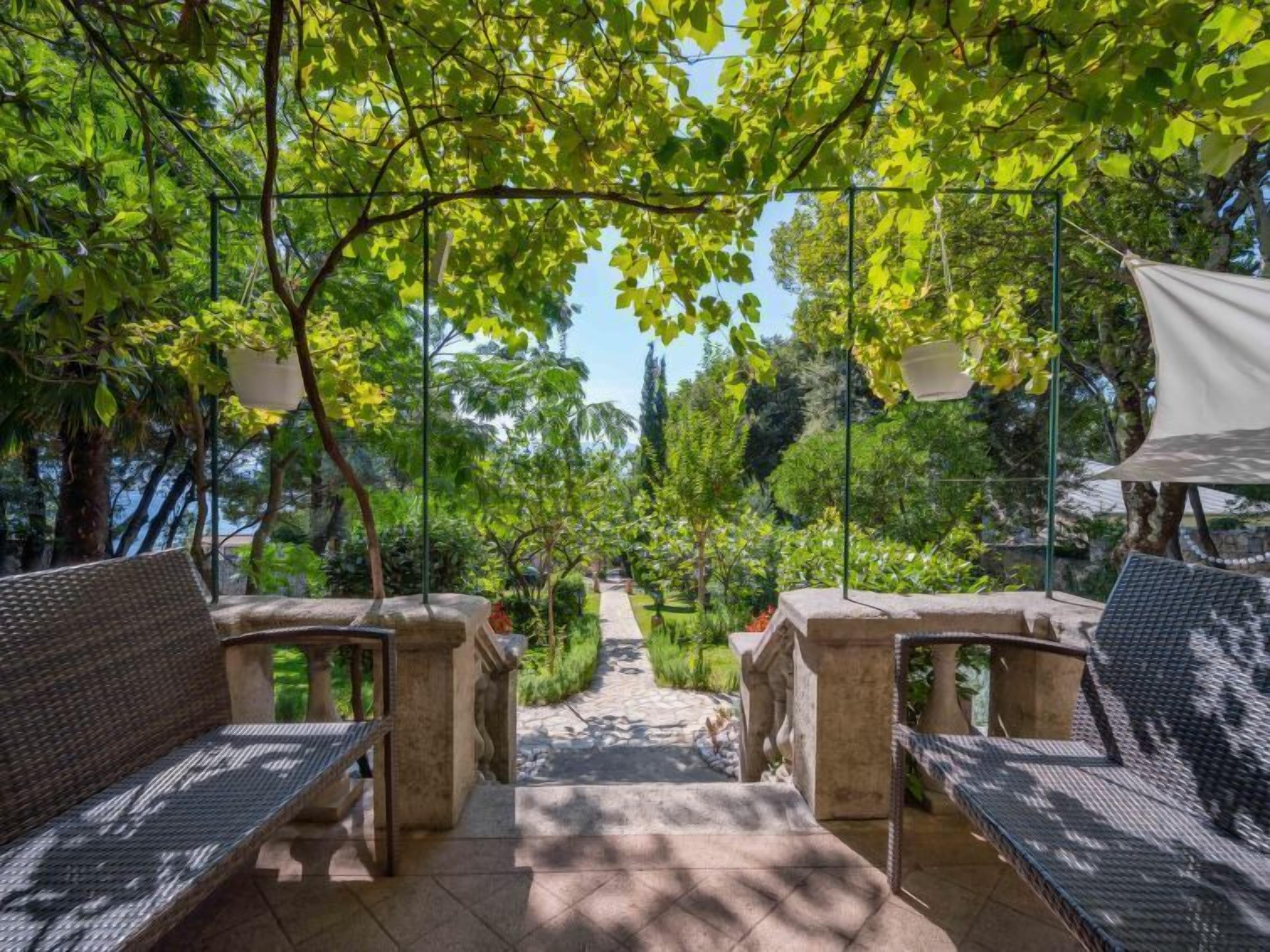 Un espacio al aire libre con bancos de piedra y un sendero que atraviesa un jardín.