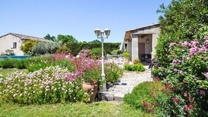 Un jardín con un sendero que conduce a un edificio con terraza.