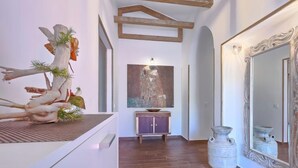 Un pasillo con piso de madera, un espejo grande y un cuadro en la pared.