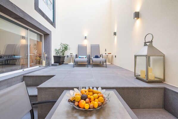 A modern outdoor seating area with a fruit bowl, two chairs, a table, and a lantern. - OLD TOWN Apartment With Interior Terrace - Barreirinha (Funchal)