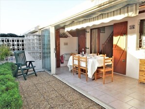 Eine Terrasse mit Esstisch, Stuhl und Feuerlöscher.