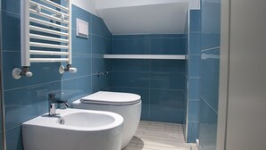 A modern bathroom with two toilets, a sink, and a shower area. - The Holy Mary inside (Tropea)
