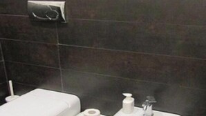 Een badkamer met toilet, bidet en wastafel.