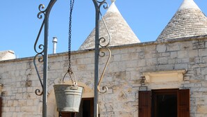 Ein Gebäude aus Stein mit einer Metall-Fontäne, Steinmauern und einem mit Fliesen belegten Innenhof.