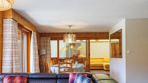 A modern living room with a leather sectional sofa, a dining area with a table and chairs, and a yellow sofa in the background. - Dents Rousses B4 by Interhome (Siviez-Nendaz)