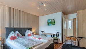 Ein modernes Schlafzimmer mit einem großen Bett, einem Schreibtisch und einem Stuhl.