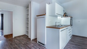 Eine moderne Küche mit weißen Schränken, einer Holz Arbeitsplatte und eingebauten Geräten.