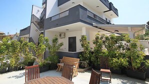 A modern two-story house with a balcony, outdoor seating, and potted plants. - Cava Larica by Interhome (Scicli)