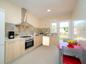 Een koelkast, een microgolfoven, een oven, kookgerei, borden en bestek